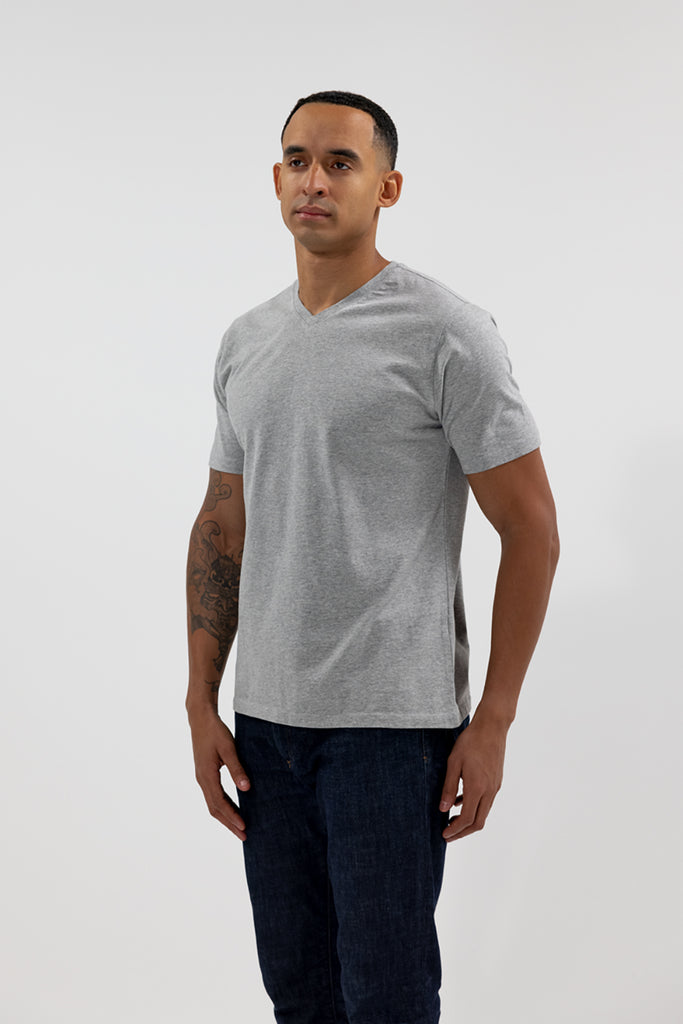 angled side view of model wearing Easy Mondays light grey heather colored V neck tee shirt