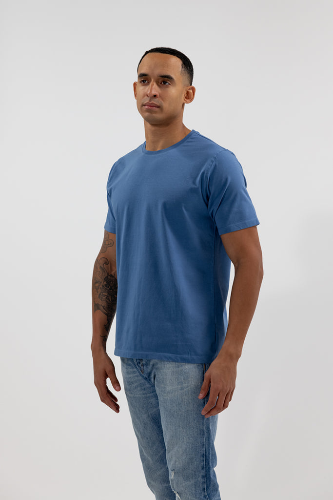 angled side view of model wearing Easy Mondays ocean blue crew neck tee shirt