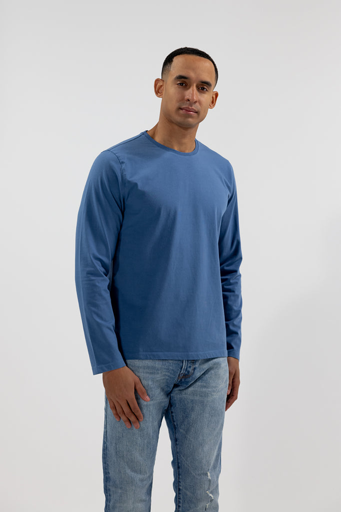front angled view of model wearing Easy Mondays medium ocean blue colored long sleeved crew neck sweatshirt