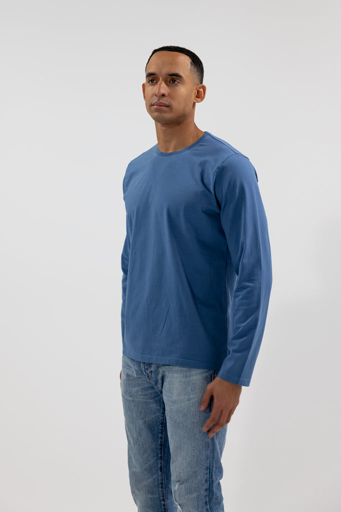 alternative angled side view of model wearing Easy Mondays medium ocean blue colored long sleeved crew neck sweatshirt