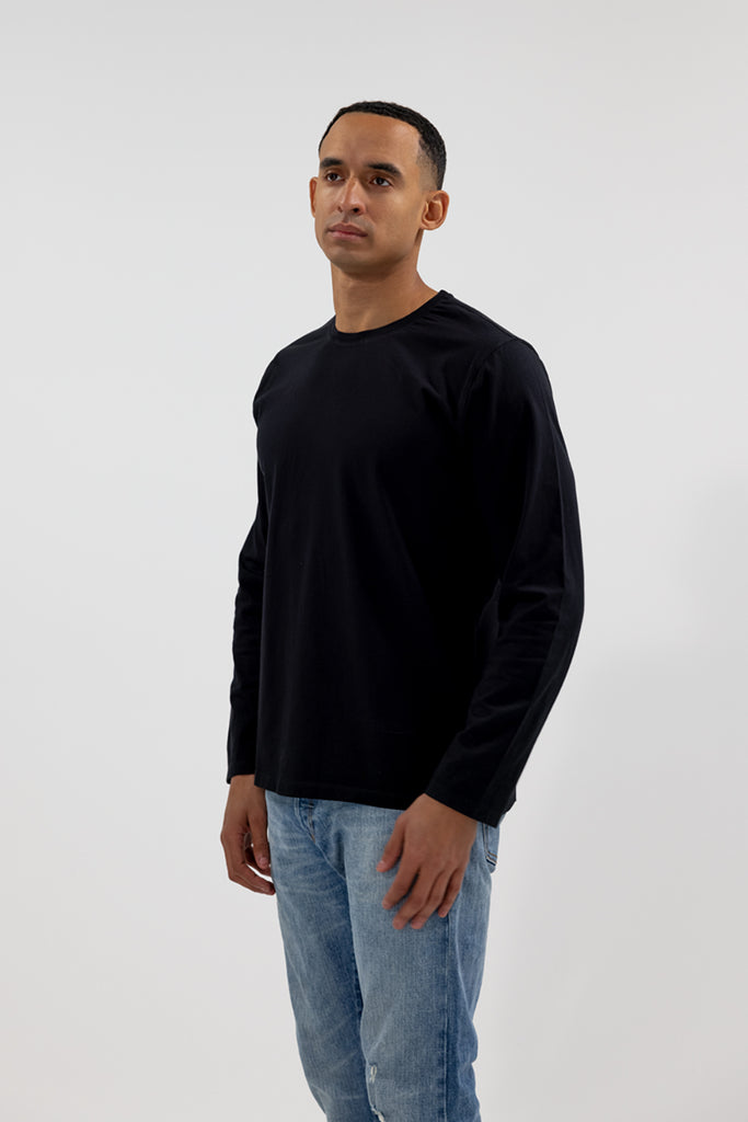 angled side view of model wearing Easy Mondays black crew neck long sleeved shirt