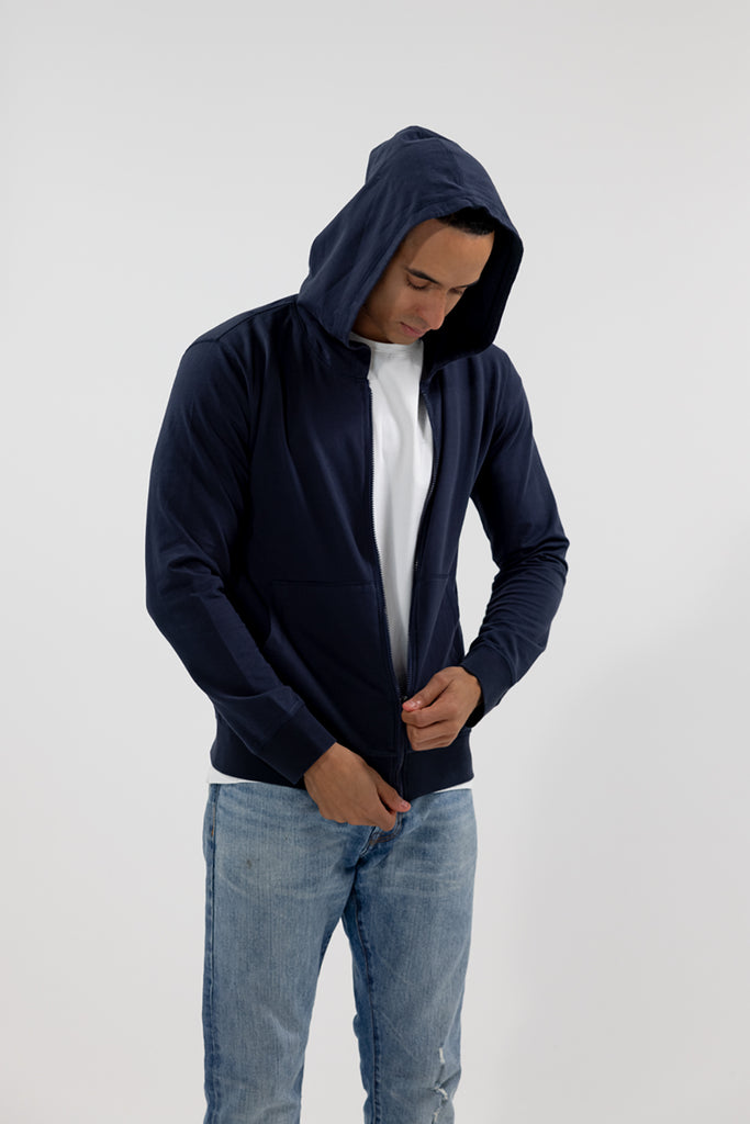 angled view of model wearing Easy Mondays dark blue navy hoodie jacket zipping up 