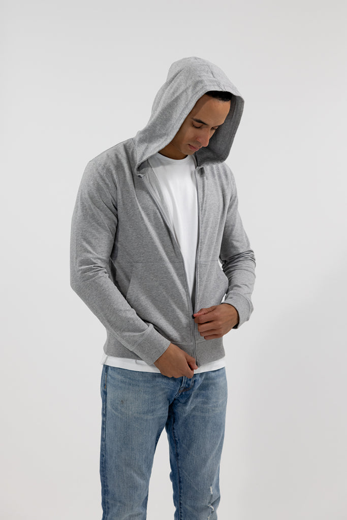 angled view of model wearing Easy Mondays light grey heather hoodie jacket zipping up
