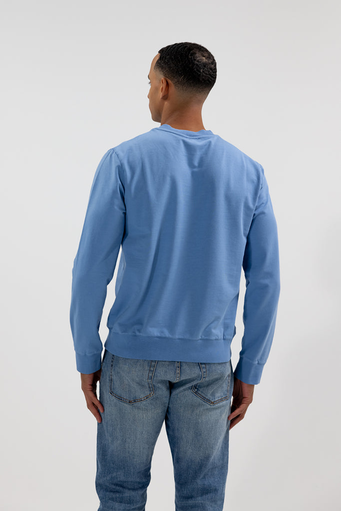 back view of model wearing Easy Mondays crew neck sweatshirt in light sky blue color