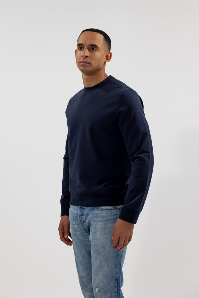 side view of model wearing Easy Mondays crew neck sweatshirt in dark blue navy color