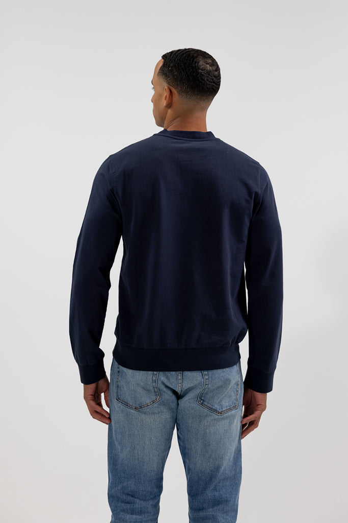 back view of model wearing Easy Mondays crew neck sweatshirt in dark blue navy color