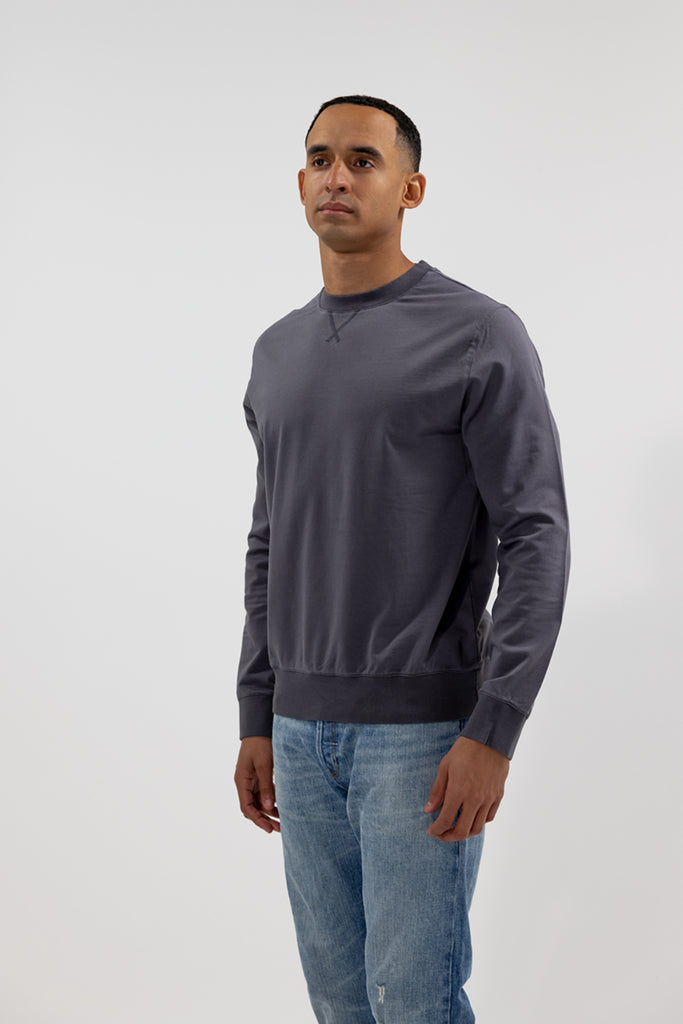 angled side view of model wearing Easy Mondays black long sleeved crew neck sweatshirt