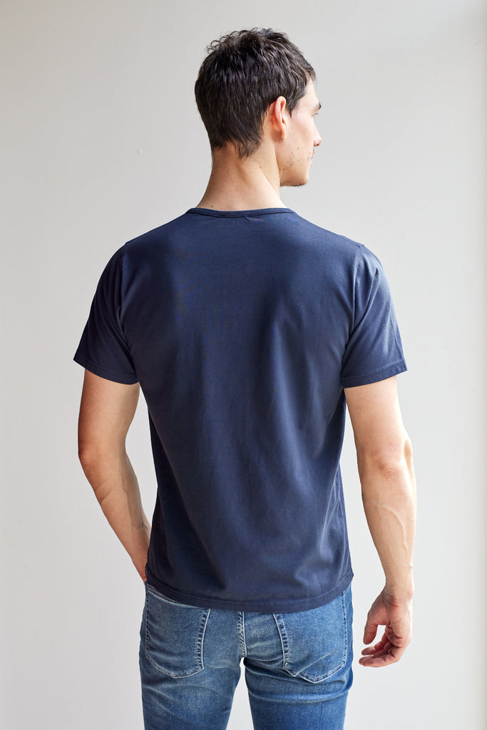 back view of model wearing Easy Mondays dark blue navy colored short sleeved Henley shirt with color-matched buttons