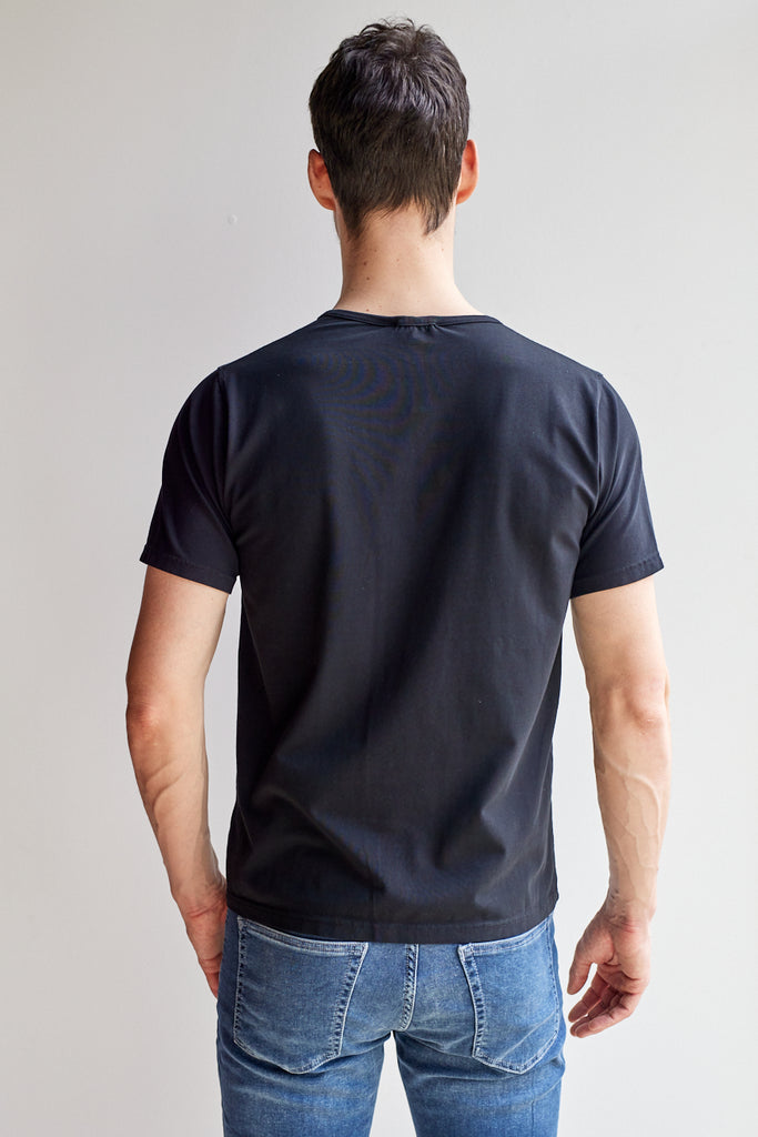 back view of model wearing Easy Mondays black short sleeved Henley shirt with color-matched buttons