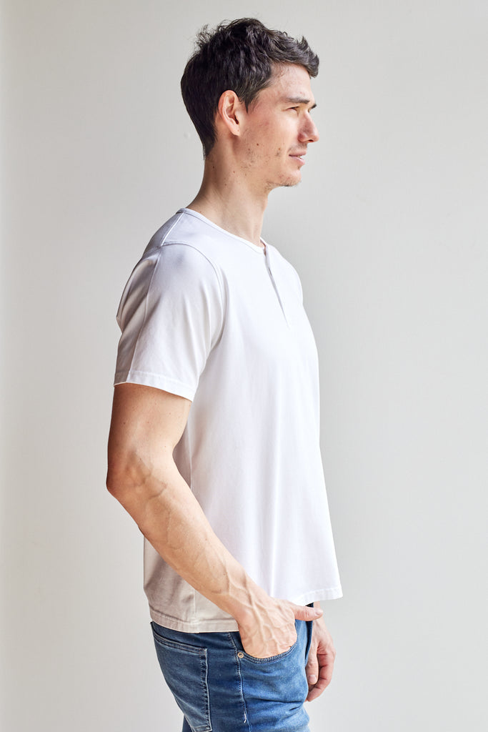 side view of model wearing Easy Mondays off white colored short sleeved Henley shirt with color-matched buttons
