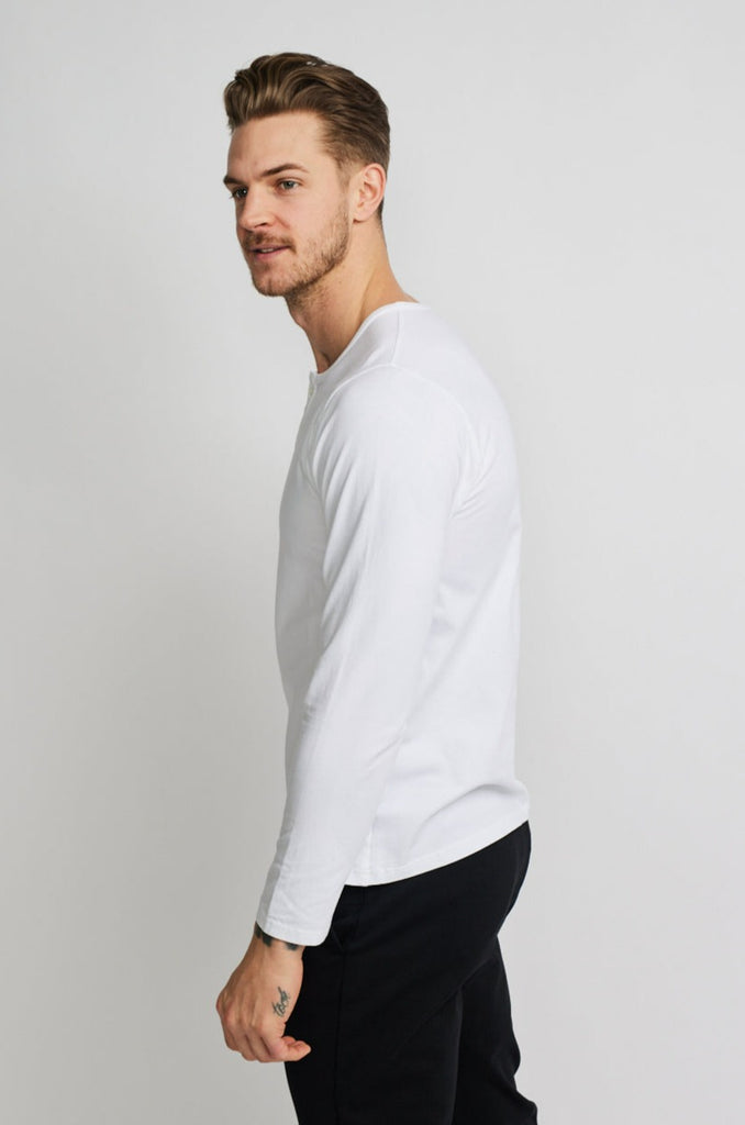 side of model wearing Easy Mondays brand long-sleeved white henley shirt with color matched buttons