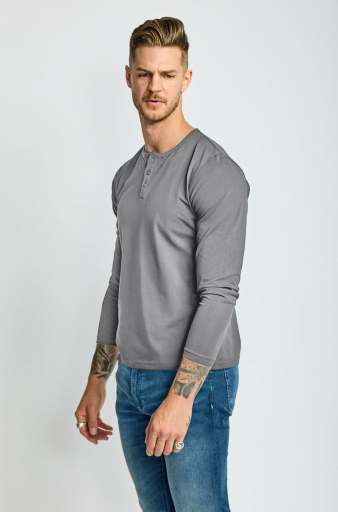 angled side view of model wearing Easy Mondays brand Henley shirt in medium grey slate color with color matched buttons