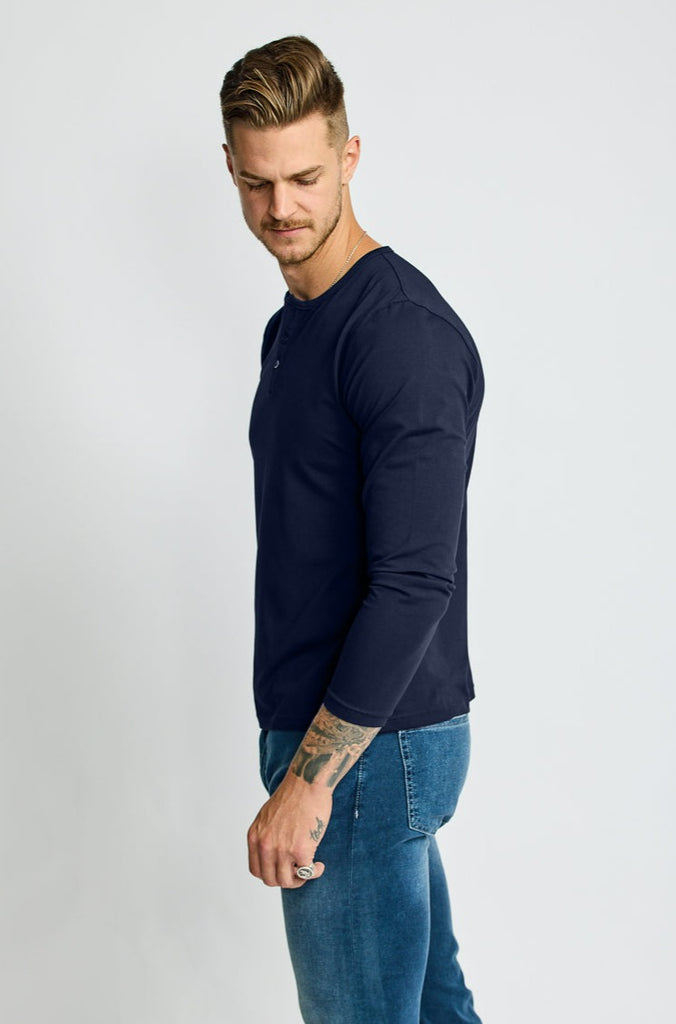 side of model wearing Easy Mondays brand Henley shirt in dark blue navy color with color matched buttons