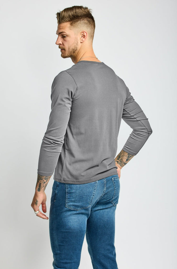 angled back view of model wearing Easy Mondays brand Henley shirt in medium grey slate color with color matched buttons