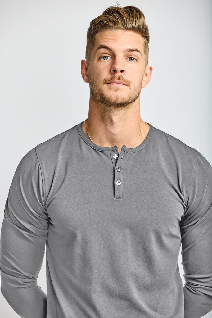 close up of front of model wearing Easy Mondays brand Henley shirt in medium grey slate color with color matched buttons