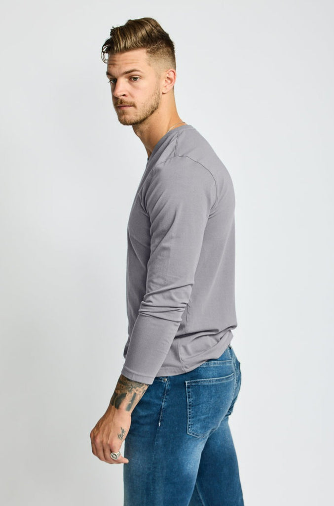 side view of  model wearing Easy Mondays brand v neck long sleeved shirt in medium grey slate color