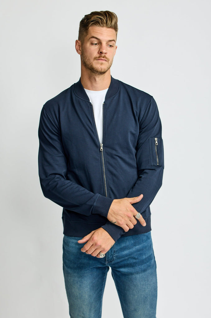 front of model wearing Easy Mondays brand full-zip fleece bomber jacket in dark blue navy color halfway zipped up