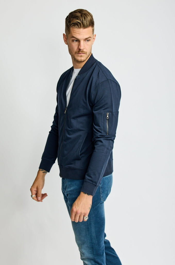 side view of model wearing Easy Mondays brand full-zip fleece bomber jacket in dark blue navy color halfway zipped up