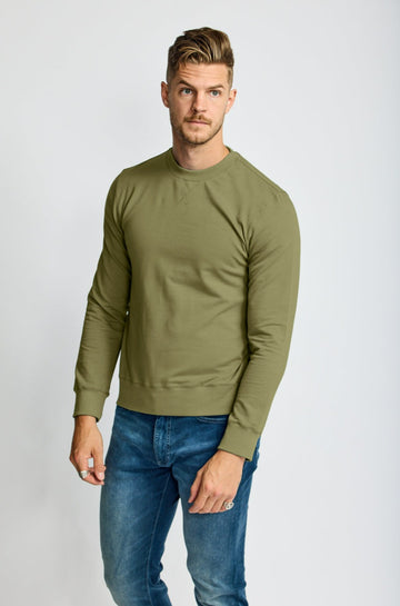 front of model wearing Easy Mondays brand crew neck sweatshirt in light forest green sage color 