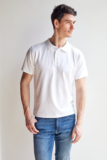front view of model wearing Easy Mondays off white colored polo shirt with color-matched buttons