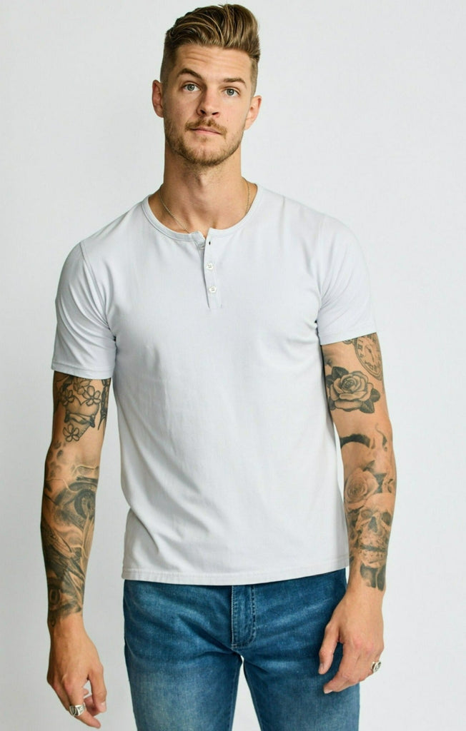 front of model wearing Easy Mondays short sleeved Henley shirt in off white cloud color with color matched buttons
