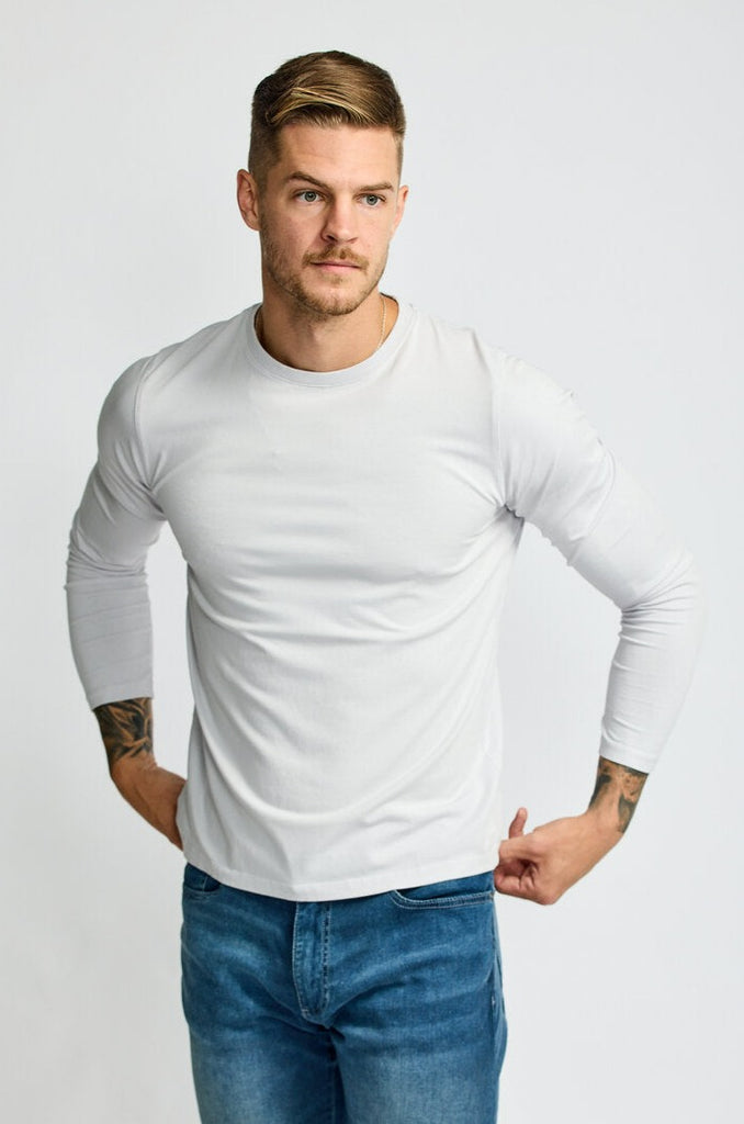 front view of model wearing Easy Monday long sleeve crew neck sweater in off-white cloud color with hands on hips