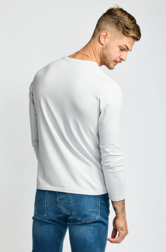 back view of model wearing Easy Monday long sleeve crew neck sweater in off-white cloud color with straight arms